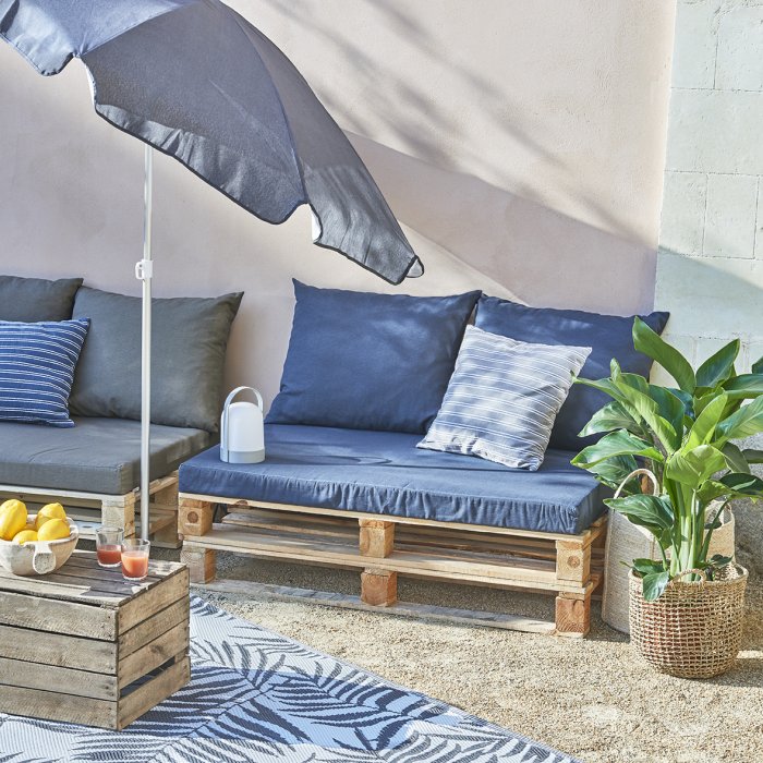 Une banquette de jardin aux coussins bleus Une banquette de jardin aux coussins bleus