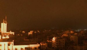Des éclairs de lumière se reflètent sur les bâtiments de Gaza après des frappes aériennes