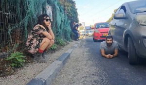 Des Israéliens s'abritent alors que les sirènes des tirs de roquettes retentissent à Tel-Aviv