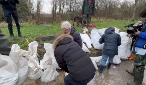 Olivier Véran aide des habitants de La Madelaine-sous-Montreuil a remplir des sacs de sable