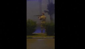 Un homme en uniforme fait feu sur fond de manifestations en Iran