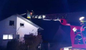 À l'aide d'une échelle, les sapeurs-pompiers éteignent la toiture d'une habitation rue du 1er mai