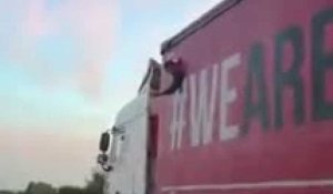 Un migrant perce la bâche d'un camion sur l'autoroute E403