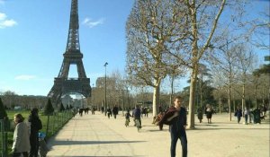Malgré le coronavirus, Parisiens et touristes profitent du soleil près de la Tour Eiffel ou sur les Champs-Elysées