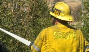 Californie: des pompiers arrosent les restes d'une maison brûlée