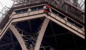 Un homme escalade la Tour Eiffel  à mains nues