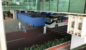 Images devant l'aéroport de Wuhan avant le départ des experts de l'OMS pour leur quarantaine