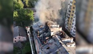 Des secouristes éteignent un incendie sur le toit d'un immeuble après des frappes à Lviv