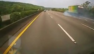 Un camion pousse une voiture sur l'autoroute