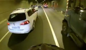 En vélo entre les camions dans un tunnel