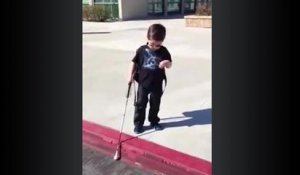Un enfant aveugle descend un trottoir