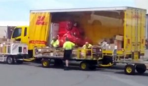 Des employés de DHL balancent des paquets dans un camion