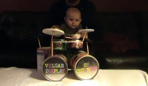 Un bébé joue de la batterie