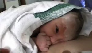 Un bébé fait un doigt d'honneur à son papa le jour de sa naissance