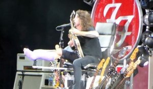 Dave Grohl des Foo Fighters assit sur un trone de guitares en live en mode Game Of Thrones