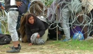 Des réfugiés entrent en Hongrie en rampant sous des barbelés