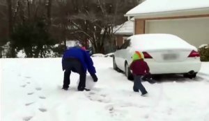 Un père jette une boule de neige démesurée sur son fils