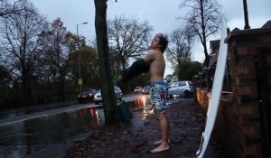 Un gars surfe sur un baril sous la pluie en pleine rue... Taré!