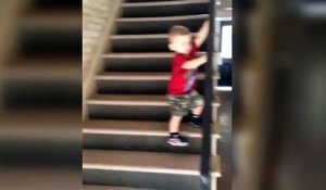 Un enfant très prudent en descendant un escalier