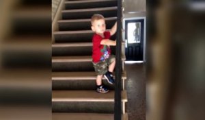 Un enfant trop prudent descend un escalier et fait un faceplant