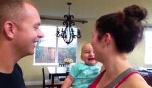 Un bébé plié de rire quand papa et maman s'embrassent