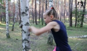 Une jeune boxeuse enchaîne les coups contre un arbre