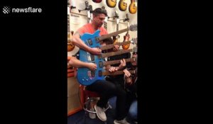 Three men perform on five-necked electric guitar