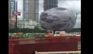 Une lune gonflable géante fonce sur des voitures dans une ville chinoise
