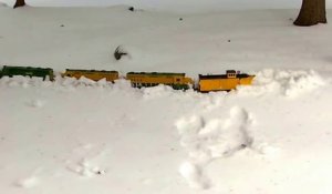 Un train miniature roule dans la neige dans le jardin !