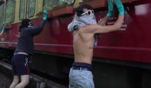 Le groupe "Guerilla Artists" décorent l'extérieur d'un train