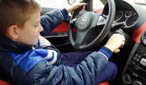 Il laisse le volant de la voiture à son gamin qui va eclater la baie vitrée de la maison