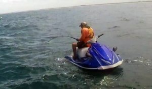 Un homme attrape un énorme mérou goliath pendant la pêche sur jet ski dans les mers agitées de Floride