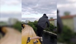 Un jeune saute dans une rivière depuis le toit d’un train en marche