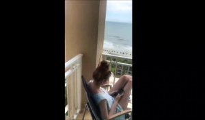 Il lui fait tellement peur qu'elle lâche son téléphone par dessus le balcon