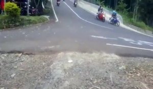 Deux hommes en scooter font une sortie de route violente dans une descente en Indonésie