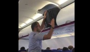 Un passager veut ranger sa valise dans un avion