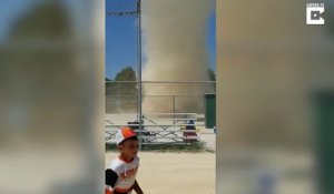 Une mini tornade de poussière balaye un terrain de baseball en plein match