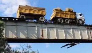 Un camion traverse en roulant sur un pont ferroviaire... Fou