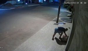 Un homme couvre un chien dans une rue