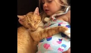Une fillette chante pour endormir son chat
