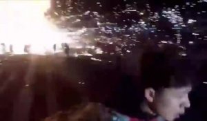 Un ballon rempli de feux d'artifice explose et retombe en formant une boule de feu sur des festivaliers