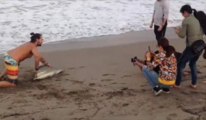 Ces touristes idiots sortent un requin de l'eau pour prendre des photos