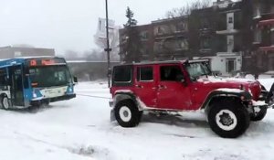 Trois SUV remorquent un bus dans la neige