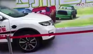 Une femme se met devant une voiture pour tester le freinage automatique d’une voiture
