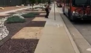 Un homme torse nu jette des pierres sur des véhicules et des bus à Los Angeles