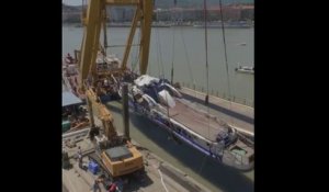 À l'aide d'une grue et de sangles, des sauveteurs ont repêché l'épave du bateau naufragé à Budapest