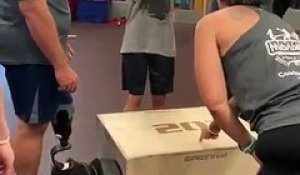 Un jeune homme sans bras saute sur une box de crossfit