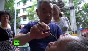 Un barbier chinois un peu dingue nettoie les yeux de ses clients avec son rasoir