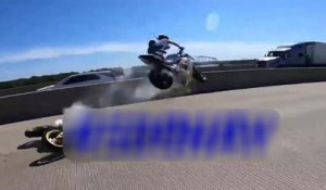 Un motard en train de faire un wheeling décolle dans les airs en roulant sur la moto de son pote