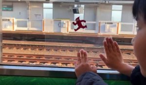 Mignon : Un enfant s'amuse en utilisant avec une feuille transparente et la vitre d'un train